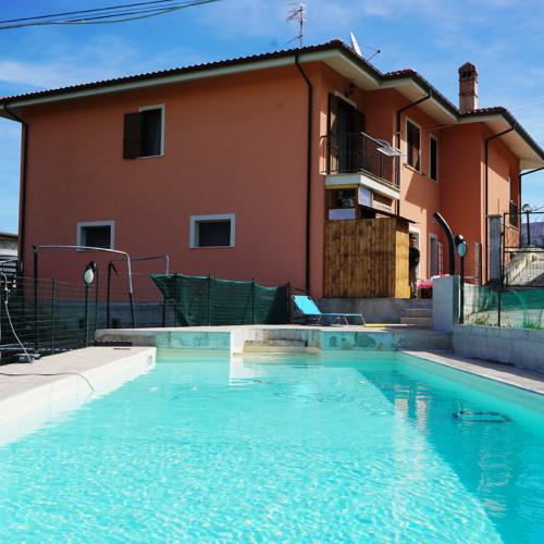 Villa con piscina e giardino, cielo sereno e ambiente tranquillo.